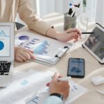 Colleagues Comparing Sales Reports