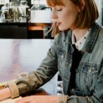 Woman writing on her notebook in a cafe